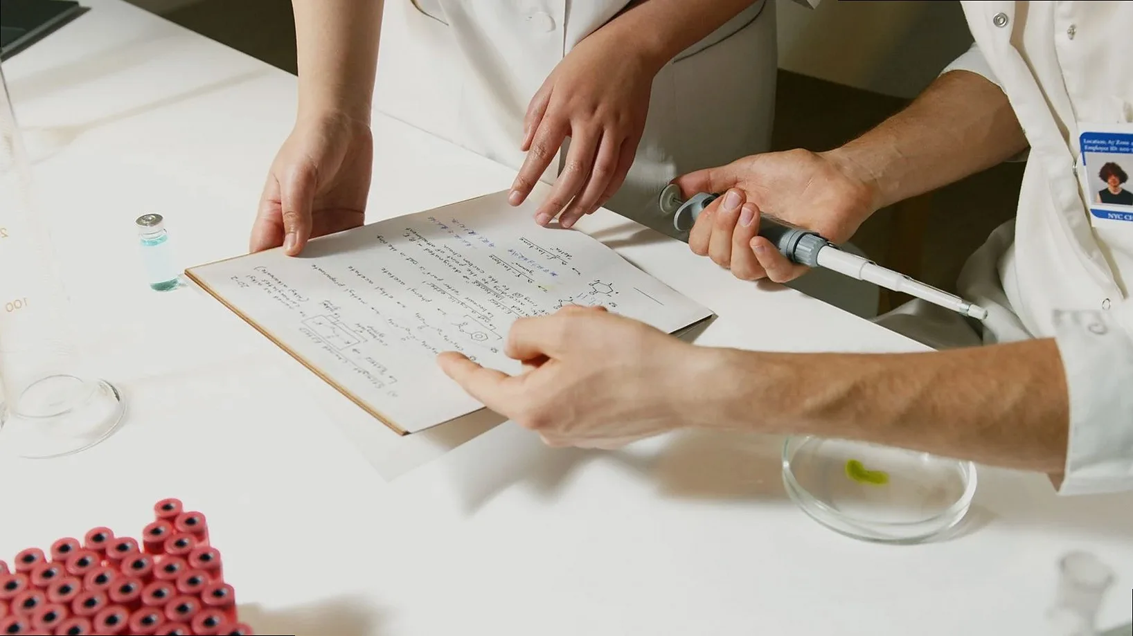 Researchers in a lab engaging in collaborative scientific research with documents and equipment.