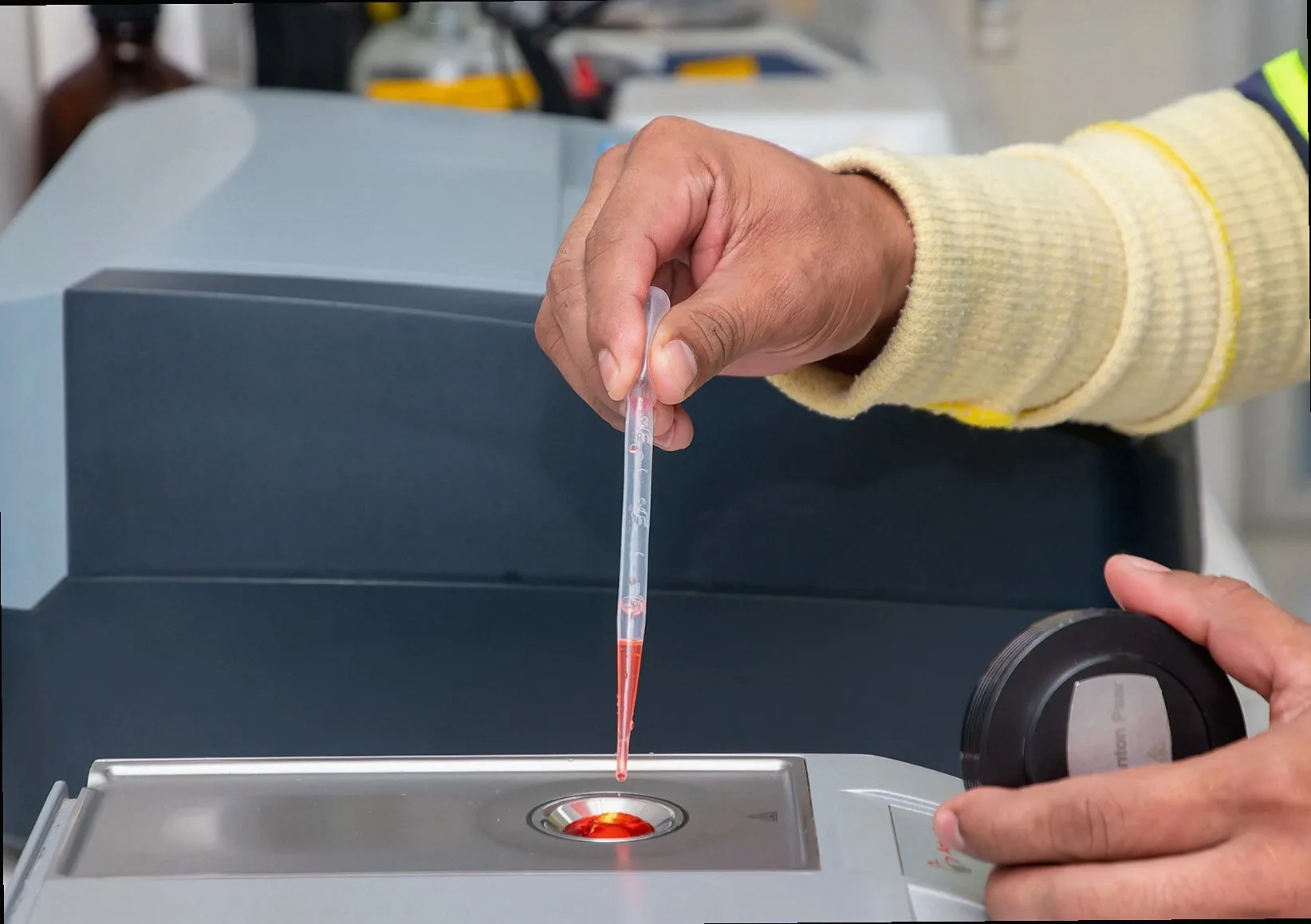 Close-up of a laboratory technician using a pipette for precise measurement in a modern lab.